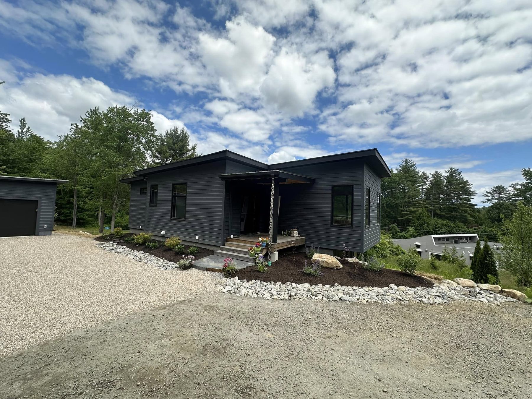 Gravel driveway and stone border at a modern home