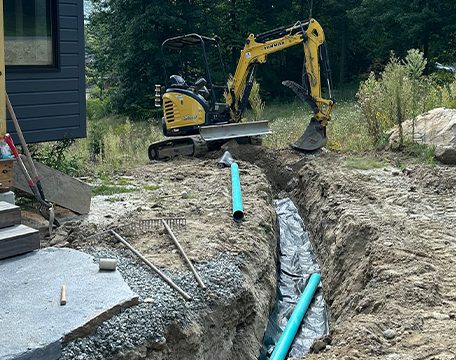 Drainage trench and pipe installed beside a house foundation