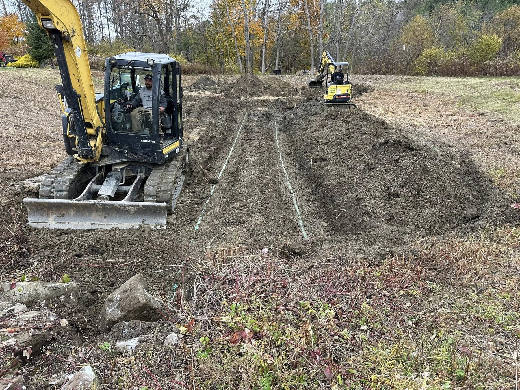 Excavator grading a site during landscape reconstruction