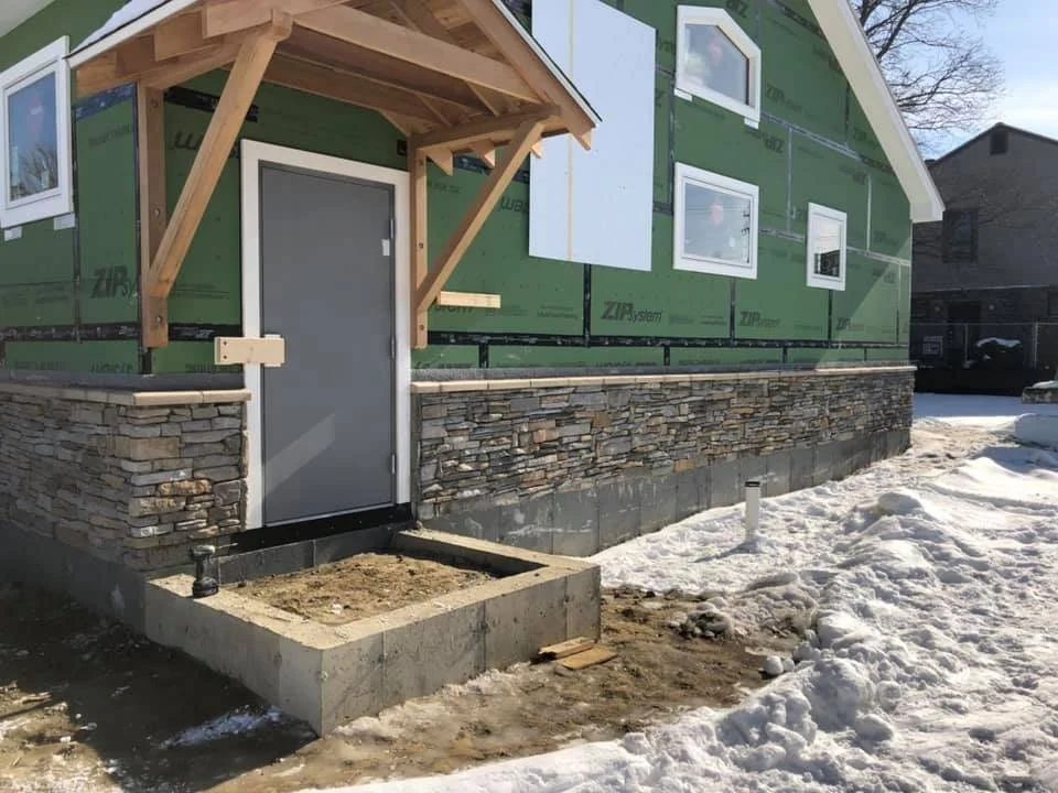 Stone veneer foundation beneath a timber-framed entry