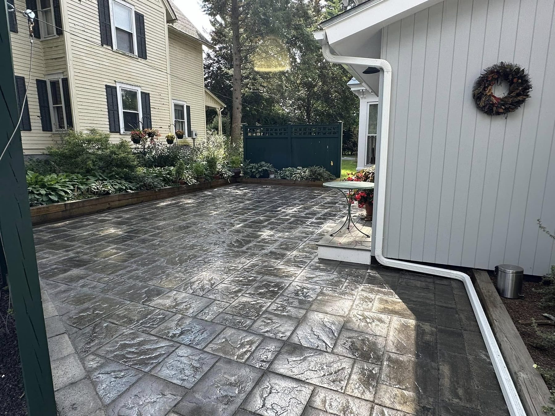 Textured paver patio beside a home entry
