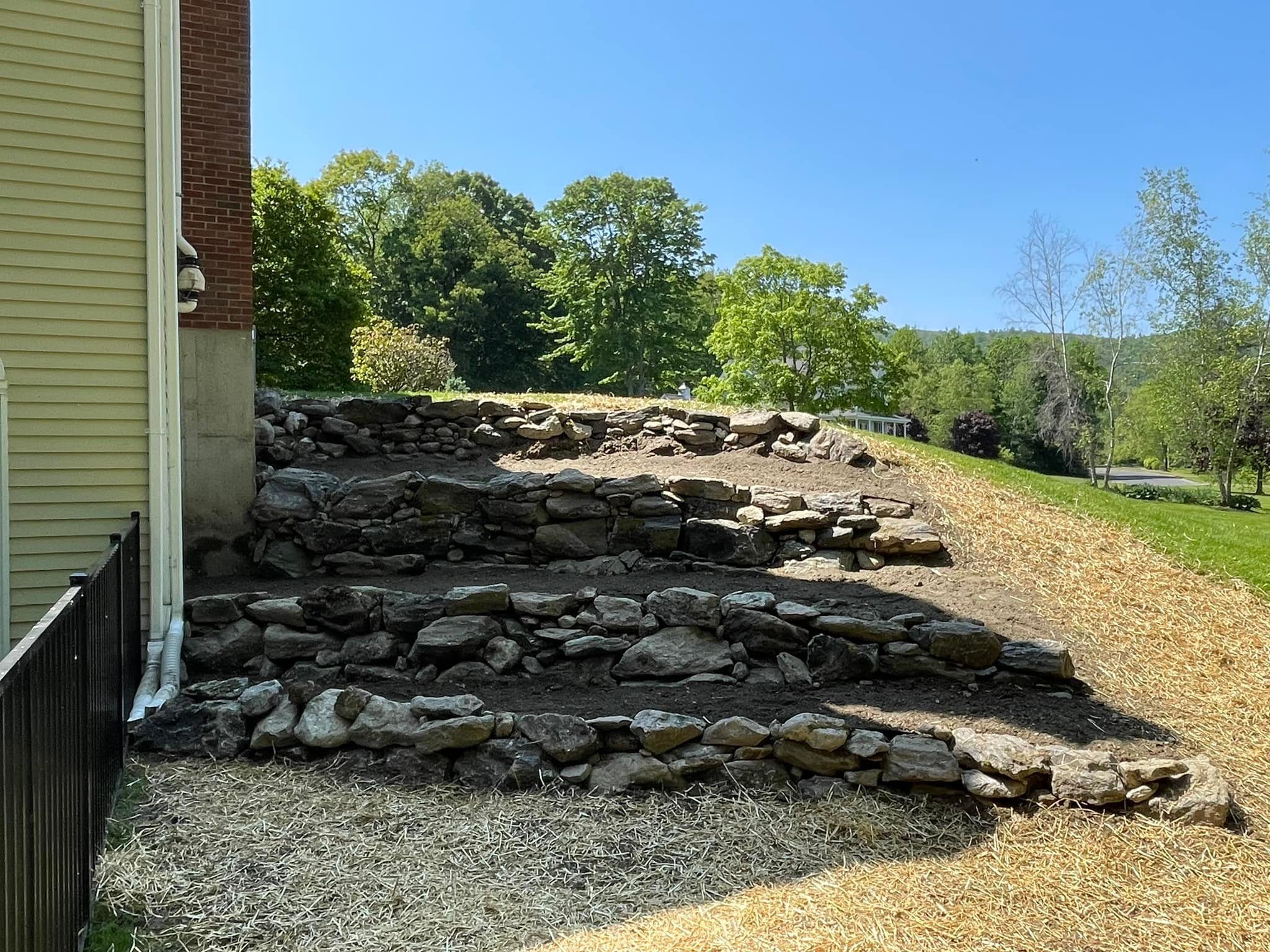 Large natural boulder retaining wall terracing a hillside