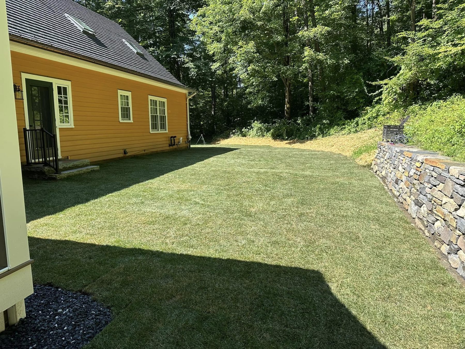 Lawn running to a fieldstone wall edge