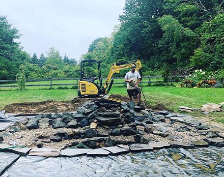 Stone being set for a pond and waterfall feature