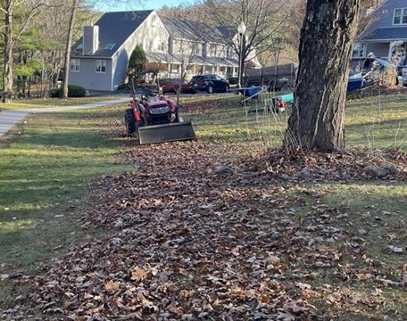 Tractor-assisted leaf cleanup on a residential property